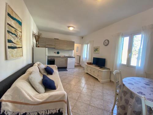a living room with a couch and a table and a kitchen at Appartamento Moneglia Holidays in Moneglia