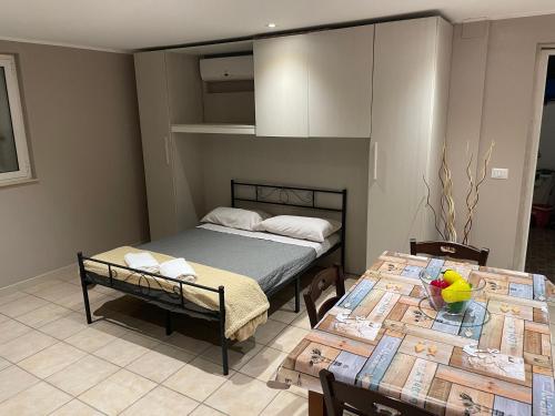 1 dormitorio con 1 cama y 2 mesas con sillas en Del Corso Apartment Palese Airport, en Bari
