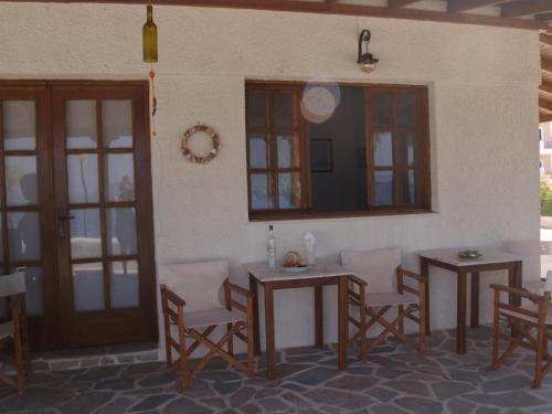 Habitación con 2 mesas, sillas y espejo. en Mandalena's, en Souvala