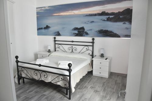 a bedroom with a bed and a painting on the wall at Angelique Affittacamere in Santa Teresa Gallura
