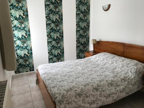 a small bedroom with a bed and floral wallpaper at Gites de Kermoel, Île de Sein in Kernascléden