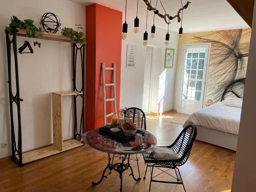 Habitación con mesa, sillas y cama en Belle Chambre Double ORANGE Tout Bonnement Bien en Putot-en-Auge