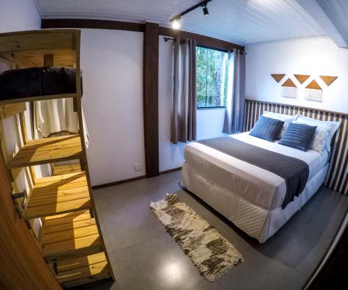 a bedroom with a bed and a bunk ladder at Pousada Refúgio do Vale - Praia do Rosa in Praia do Rosa