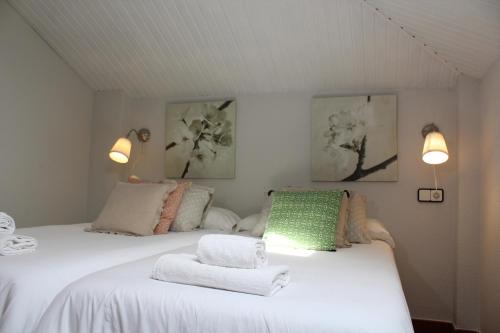 a bedroom with two beds with towels on them at Apartamentos Los Hidalgos in Santillana del Mar