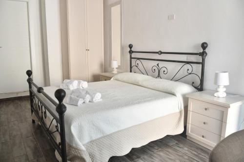 a bedroom with a black bed with white sheets at Angelique Affittacamere in Santa Teresa Gallura