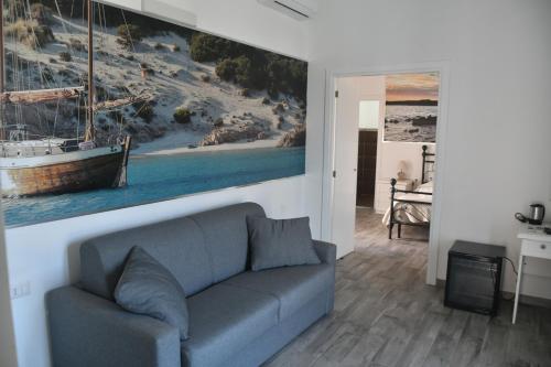 a living room with a couch and a painting on the wall at Angelique Affittacamere in Santa Teresa Gallura
