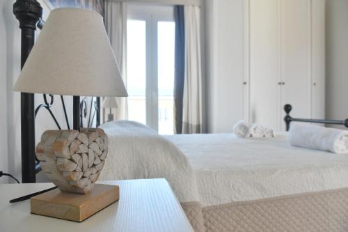 a lamp sitting on a table next to a bed at Angelique Affittacamere in Santa Teresa Gallura