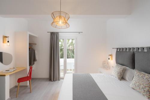a bedroom with a bed and a desk and a chair at Sunray Lodgings in Kamari