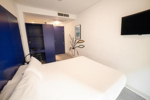 
a bedroom with a white bed and white walls at Hostal Albany in León
