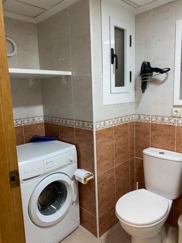 uma casa de banho com uma máquina de lavar roupa e um WC em MY SUNNY PAYMA BEACH Apartment em Benidorm