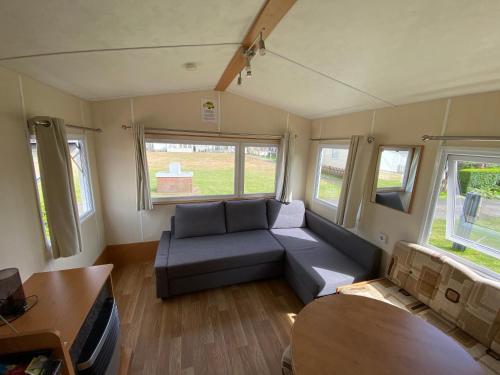 a living room with a couch and a table at Chalet Formentera in de duinen van IJmuiden aan Zee in IJmuiden