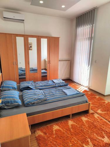 sypialnia z dużym łóżkiem i niebieskimi poduszkami w obiekcie Apartman br 4 w mieście Bijeljina