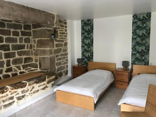 2 camas en una habitación con una pared de piedra en Gite de Kermoel, île de Bréhat, en Kernascléden