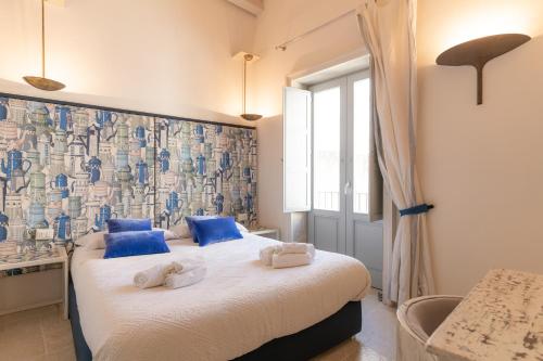 a bedroom with a bed with blue pillows at Blue Levante Vista Mare con terrazza in Syracuse