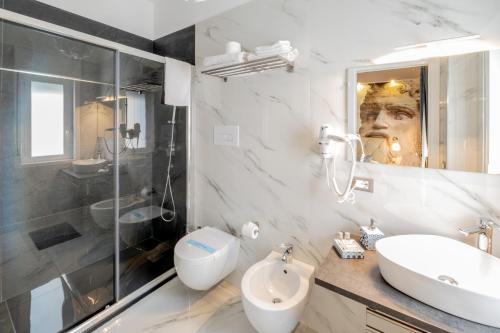 a bathroom with a sink and a toilet and a shower at Eolian Port B&B in Milazzo