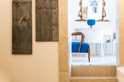 a hallway with a blue chair and a painting on the wall at Blue Levante Vista Mare con terrazza in Syracuse