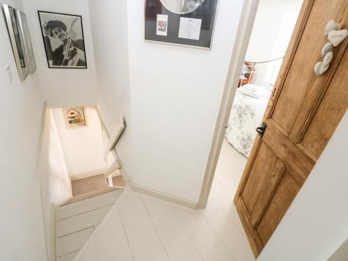 a staircase with a wooden door in a room at Mallards in Pentewan