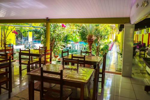 un restaurante con mesas y sillas y un patio en Pousada Aquarius, en Aruanã