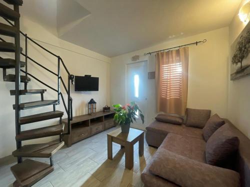 a living room with a couch and a stair case at Studio Apartment Dona in Trogir