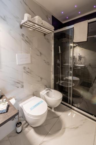 a white bathroom with a toilet and a sink at Eolian Port B&B in Milazzo