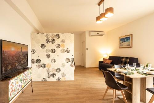 uma sala de estar com uma mesa e uma sala de estar com uma televisão em BORGOROMA - Business & Residence em Verona