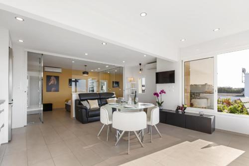 une cuisine et un salon avec une table et des chaises dans l'établissement Village Naturiste R4N - La Villa Rocca Luxe, au Cap d'Agde