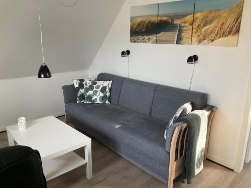 een woonkamer met een bank en een tafel bij Vesterhavsvej in Hvide Sande