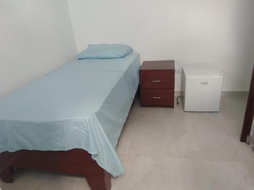 1 dormitorio con 1 cama, vestidor y mesita de noche en RECIDENCIAL MIGNOLI en Boca Chica