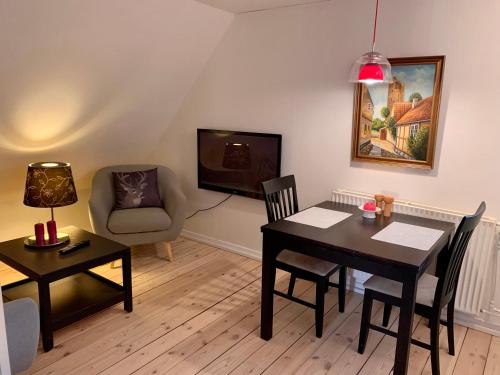 een woonkamer met een tafel en een stoel bij Jægergård in Skærbæk