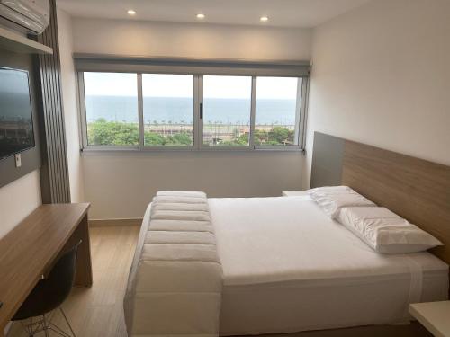 a bedroom with a bed and a large window at 25 homeApart in Encarnación