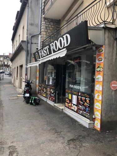 a fast food store on the side of a street at Logement à Brive - proche de la gare et du centre ville - Climatisation - fibre internet - stationnements gratuits in Brive-la-Gaillarde