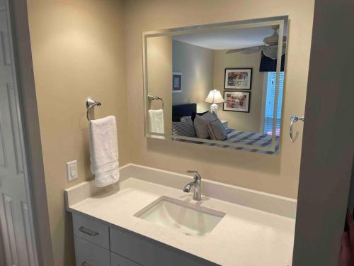 a bathroom with a sink and a large mirror at In the Heart of Harbour Town 2BR 2BA Pool Access Close to Beach in Hilton Head Island