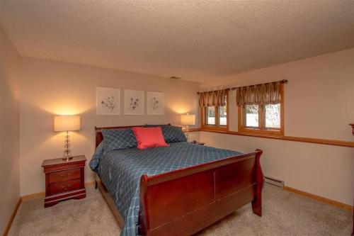 a bedroom with a bed with a red pillow at Relaxing Riverside Retreat - StoryLand, Attitash, North Conway in Bartlett