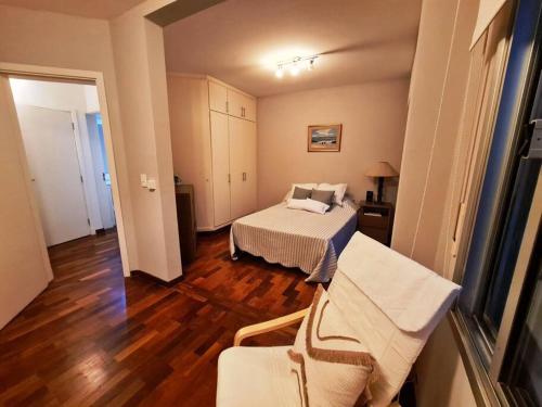 a bedroom with a bed and a chair in it at Hermosa habitación en apartamento en Carrasco - Comparte Apartamento conmigo in Montevideo
