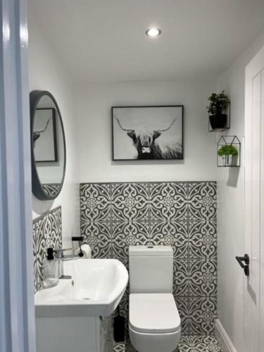 a bathroom with a toilet and a sink at Orchard Lodge-Coastal Retreat, newly built hideaway with village views and private terrace in Saint Brides Major
