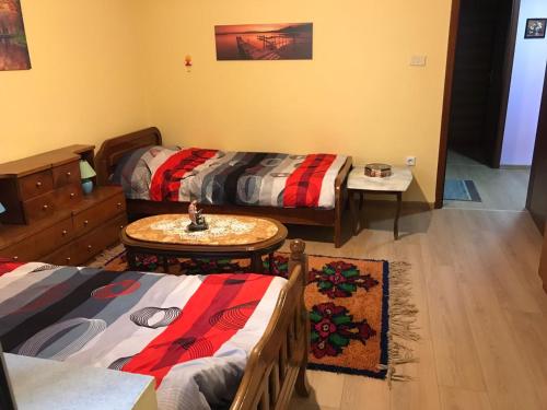 een woonkamer met 2 bedden en een tafel bij Laku Apartment - At The Heart of Tirana in Tirana