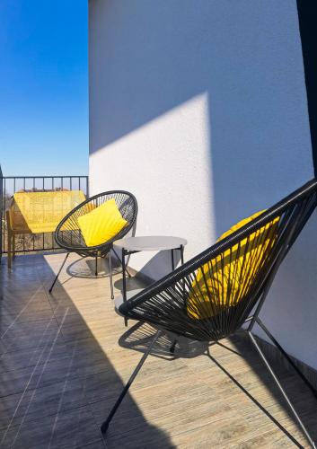 2 sillas amarillas y una mesa en el balcón en Apartament Loft Studio Airport blisko lotniska Zarembowicza lotnisko en Breslavia