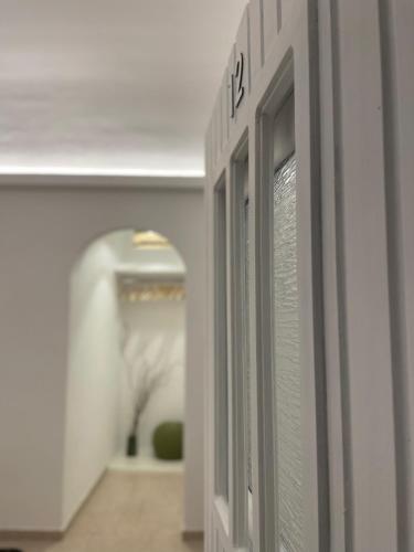 a hallway with a row of doors in a building at Cal Day Rooms Santorini in Perissa