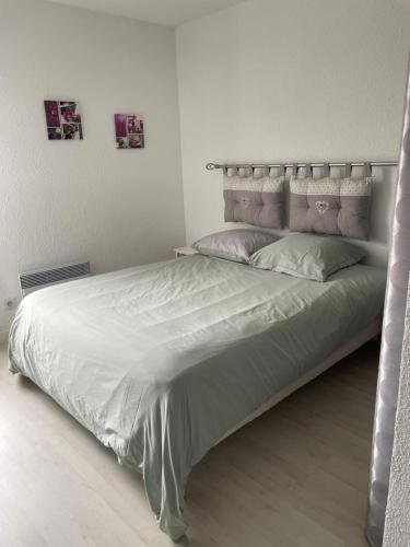 a bedroom with a large bed with white sheets and pillows at APPARTEMENT LUMINEUX SUR LE PORT! 5 MN DE LA PLAGE AVEC PARKING PRIVE in Cap d'Agde