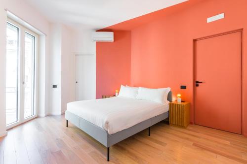 um quarto com uma cama com uma parede laranja em Starhost - Casa GIULIA em Salerno