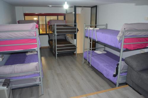 a room with three bunk beds with purple sheets at Santiago de Vilavella in Redondela