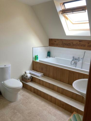 a bathroom with a tub and a toilet and a sink at Springbank Apartment - Sleeps 4 - Pet Friendly in Fort William