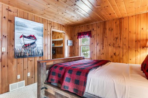 a bedroom with a bed in a wooden cabin at Annabelle Log Home in Presque Isle