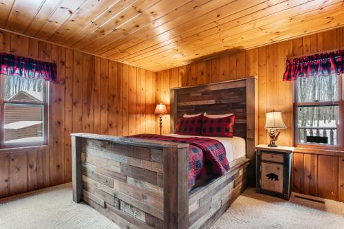 a bedroom with a bed in a wooden room at Annabelle Log Home in Presque Isle
