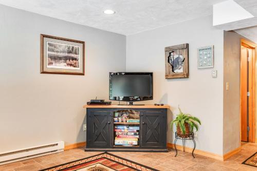 a tv sitting on top of a cabinet in a room at Annabelle Log Home in Presque Isle