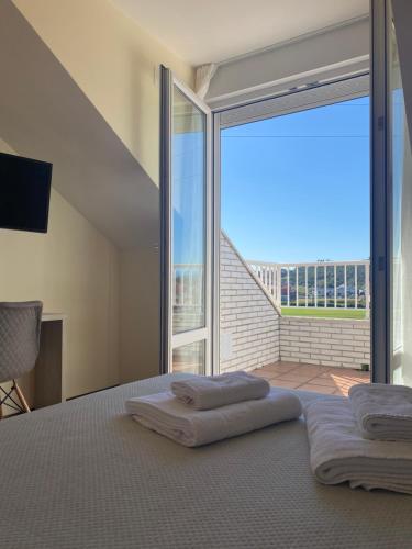 a bedroom with a bed and a large glass window at Posada H.El Alba in Boó de Piélagos
