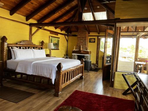 a bedroom with a large bed and a fireplace at Hacienda Jimenita Wildlife Reserve in Puembo
