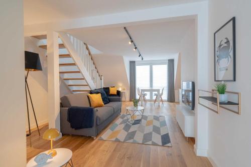 a living room with a couch and a staircase at LightHouse Whg 5 in Norderney