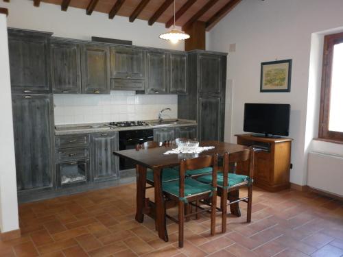 a kitchen with wooden cabinets and a table with chairs at Podere Le Grotte in San Gimignano