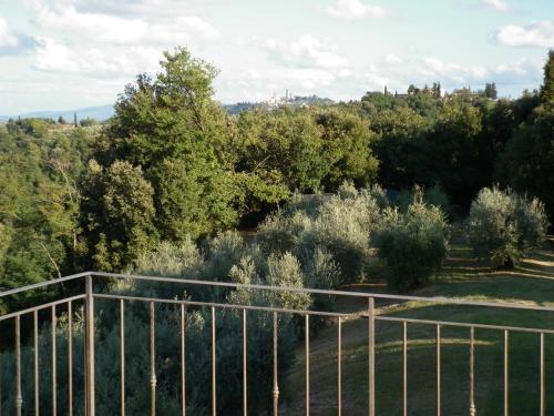 a view of a garden with trees and a fence at Podere Le Grotte in San Gimignano